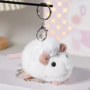 Primo piano di un grazioso portachiavi in peluche di topo bianco con un cappello da cuoco.