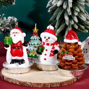Primo piano di simpatiche candele natalizie con Babbo Natale, pupazzo di neve, pino.