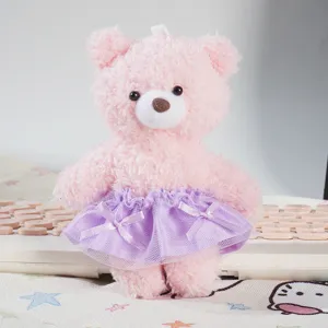 Dettaglio bambola orsetto peluche rosa con gonna tutu fiocco viola accessorio moda.