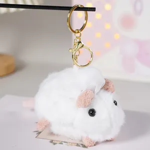 Primo piano dettagliato del portachiavi in peluche di topo bianco con cappello da cuoco.
