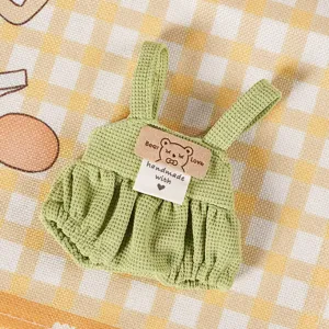 Vista dettagliata di salopette per bambola in maglia waffle verde, accessorio peluche.