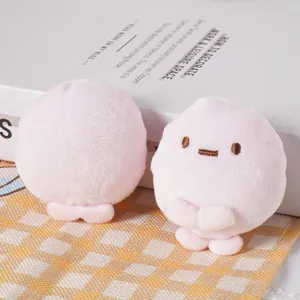 Close-up of cute pink plush doll toy, soft texture with delicate embroidered face and lovely limbs.