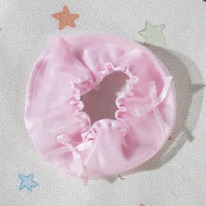 Primo piano di mini gonna in pizzo per bambola rosa, fiocchi carini, accessorio fai da te ideale.