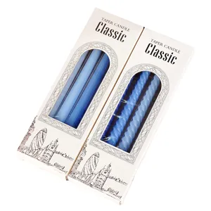 Primo piano dettagliato di candele coniche sfumate in elegante confezione regalo.