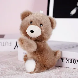 Close-up of cute brown plush bear toy with white muzzle, soft desktop decor detail shot.
