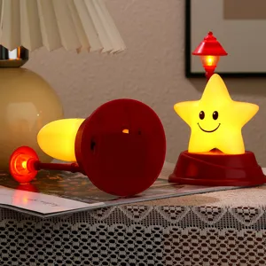 Simpatica lampada LED notturna a stella con base rossa e mini lampione, arredamento.
