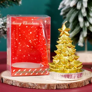 Primo piano della candela albero di Natale dorata con base in alluminio e confezione.