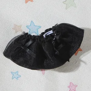 Primo piano dettagliato di una gonna per bambole in tulle nero con fiocco ed elastico.