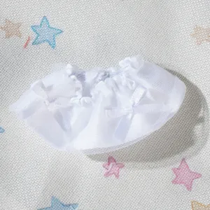 Primo piano dettaglio della mini gonna in pizzo bianco per bambola con grazioso fiocco.