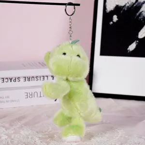 Detailed shot of cute green plush dinosaur keychain, soft toy pendant with metal ring.