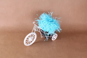 Gedetailleerd aanzicht van blauw opvulsel voor geschenkdozen in een witte miniatuurfiets.