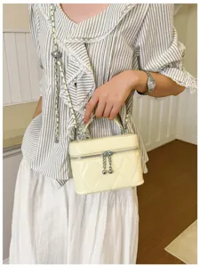Detailed view of the stylish yellow quilted box handbag with metal chain handle and strap.