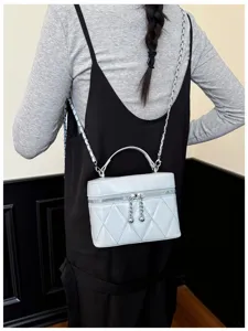 Detailed view of a light blue quilted chain cross-body box bag showcasing elegant stitching.