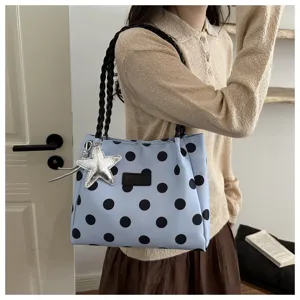 Borsa a tracolla azzurra a pois con manici intrecciati neri e ciondolo a stella per la vita.