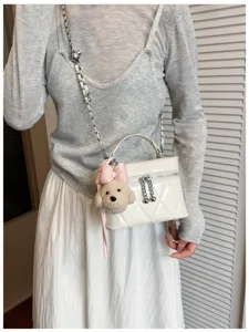 Detailed view of women's autumn chain crossbody bag with cute puppy pendant and diamond quilt.
