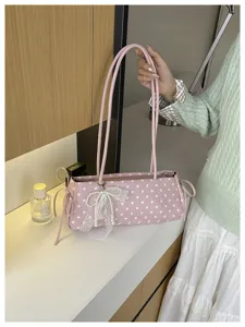 Borsa a spalla rosa a pois con fiocco in pizzo e perle, ideale per un look dolce e raffinato.