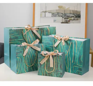 Detail groen gouden papier cadeauzak, elegante shopper met abstract patroon en strikhandvat.