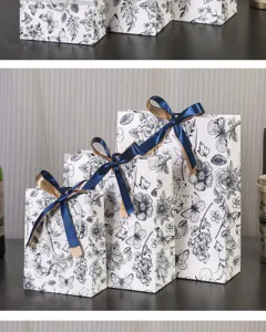 Sacs cadeaux rétro à fleurs en carton blanc avec rubans bleus, emballage élégant pour fêtes.