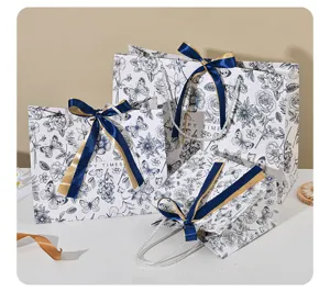 Blauwwitte bloemen papieren cadeauzakjes met elegante lintstrikken voor feestelijke presentjes.