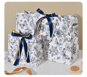 Blauwwitte bloemige cadeautassen van papier met linten, elegante verpakking voor feestdagen.