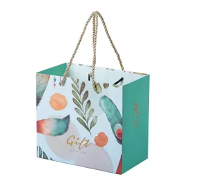 Elegante papieren draagtas met aquarel bladmotief en stevige touw handvatten voor cadeaus.