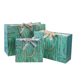 Detailweergave van groene en gouden papieren cadeautassen met elegante strikken.