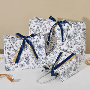 Decoratieve papieren cadeautasjes met bloemenprint en blauwe strikken voor feestdagen.
