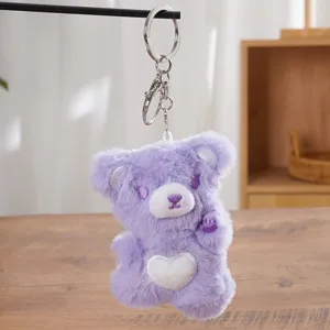 Detailed close-up view of the purple plush bear keychain featuring a white heart belly and metal ring.