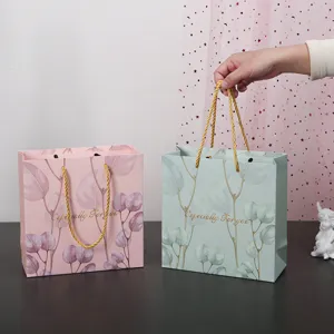 Sacchetto regalo in carta con eucalipto, elegante borsa rosa e verde per cosmetici e regali.
