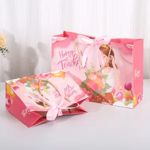 Roze cadeautjes tassen met strik en leraar motief, perfect voor het inpakken van cadeaus.