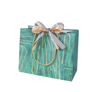 Elegante papieren cadeauzak met strik en handvatten, ideaal voor kleding- en cosmeticaverpakking.