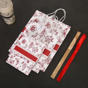 Sacs cadeaux rétro à fleurs en carton blanc avec poignées et rubans pour les fêtes.