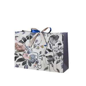 Vintage bloemen papieren cadeautas met lint handvatten, elegante horizontale verpakking.