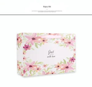 Cadeauzak van papier met roze bloemmotief en lint voor verjaardagsfeestje verpakking doos