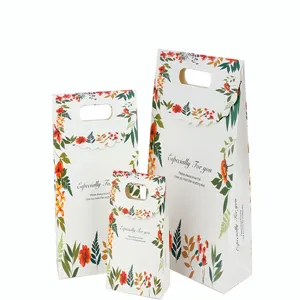 Gedetailleerd overzicht van witte papieren geschenkzakjes met bloemenpatroon.