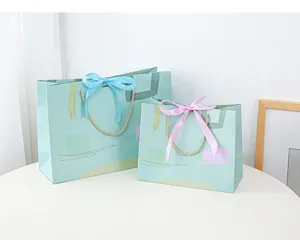 Gedetailleerd overzicht van frisse papieren cadeautassen met mooie linten op tafel.