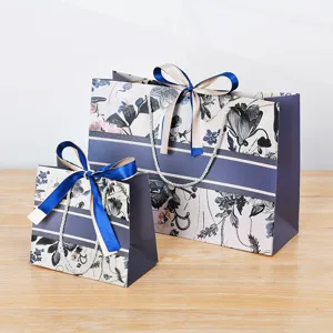 Elegante papieren geschenktassen met bloemenmotief en linten, perfect voor bedrijfsverpakkingen.