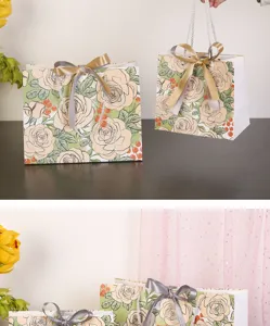 Gedetailleerd overzicht van papieren geschenkzakjes met rozenmotief en satijnen linten.
