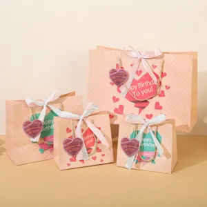 Set di sacchetti regalo in carta rosa con etichette a cuore e nastri per compleanno.