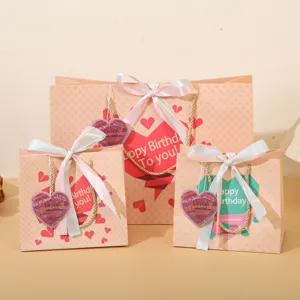 Vista dettagliata di sacchetti regalo in carta rosa con nastri per feste di compleanno.