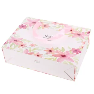 Roze bloemige papieren geschenkzak met satijnen lint handvatten voor Valentijnsdag en feest.