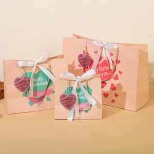 Sacchetti regalo in carta rosa con nastri e etichette a cuore per confezionare regali di compleanno.