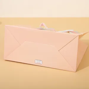 Vista dettagliata inferiore della grande borsa regalo in carta rosa con struttura e etichetta.
