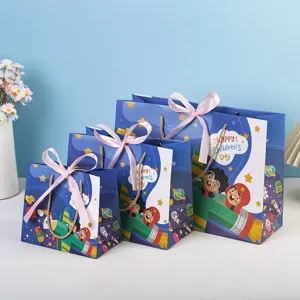 Children's Day gift paper bags set with cute cartoon space theme design and pink ribbon bows.