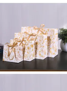 Bloemige geschenkzakken van papier met gouden linten, elegante verpakkingszakken.