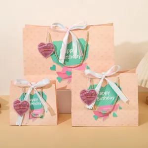 Grande sacchetto regalo di compleanno in carta rosa con nastro e etichetta a cuore per festa