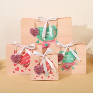 Sacchetti regalo di compleanno rosa con nastri e carte a cuore per confezioni di feste e regali.