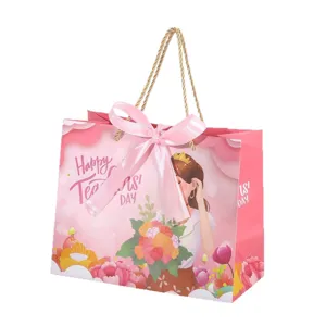 Mooie roze papieren cadeauzak met stijlvolle lintstrik en vrolijke bloemenillustratie.
