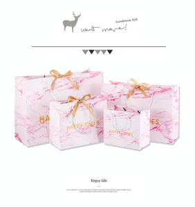 Roze marmer patroon papieren cadeautas met gouden lint handvatten voor verpakking en details