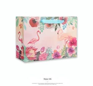 Papieren cadeauzakje met aquarel flamingo en blauw lint voor feestjes en winkelen.